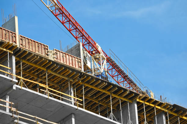 Crane and building under construction against blue sky