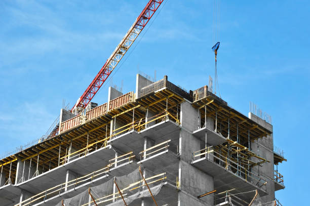 Crane and building under construction against blue sky